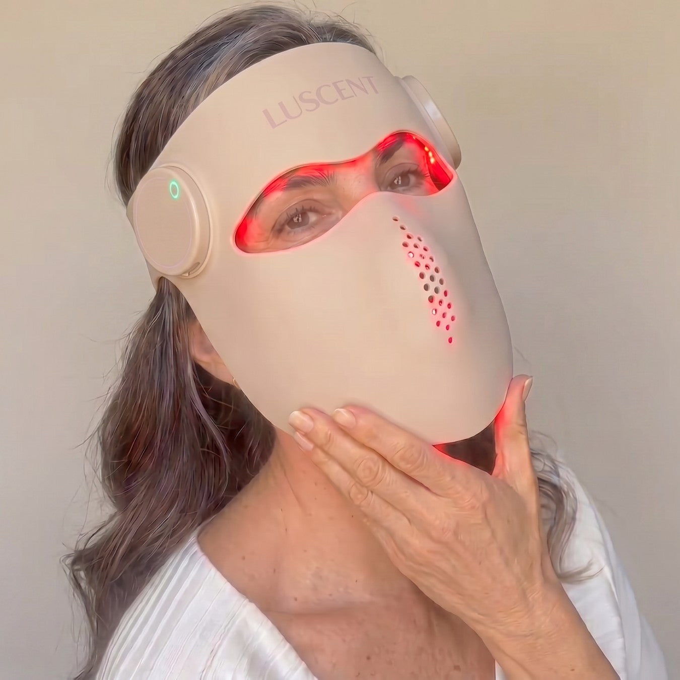 Person wearing a LUSCENT RED RED LIGHT THERAPY face mask with visible light components.