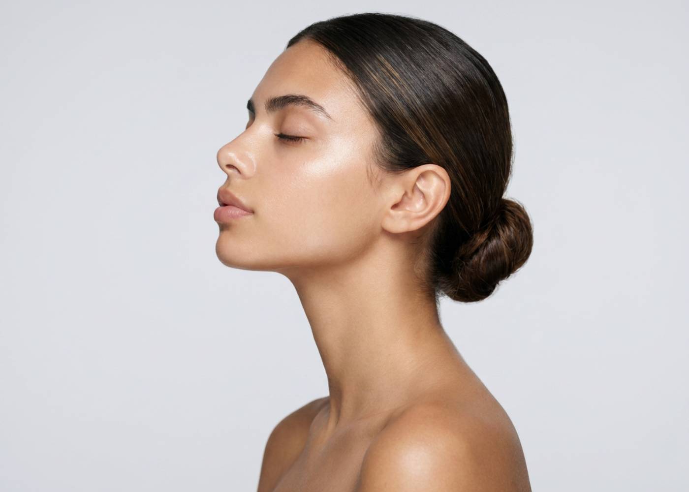 Woman with a smooth neck and shoulders against a light gray background