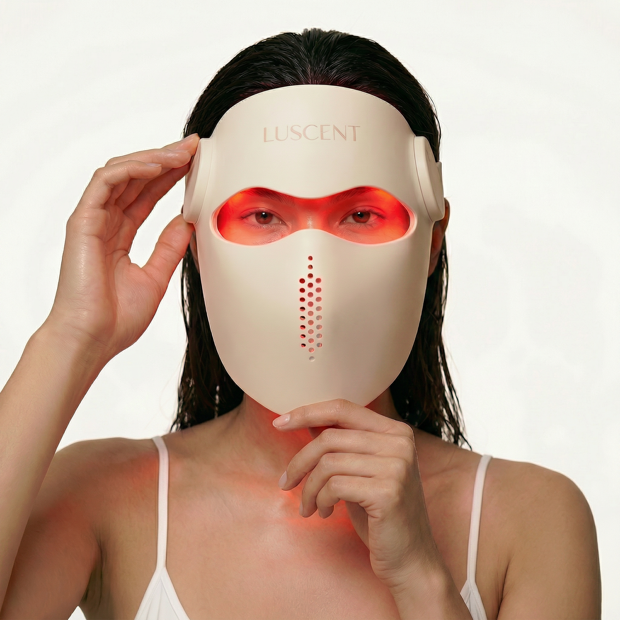 Woman wearing a Luscent LED face mask on a plain background